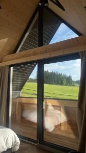 een kamer met een groot raam in een hut bij Za Krzemionką in Maruszyna