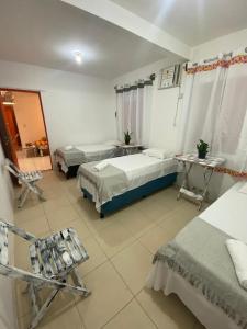 Un dormitorio con dos camas y una mesa y sillas. en Xicabacana, en Mata de Sao Joao