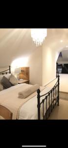a bedroom with a bed and a chandelier at Highcroft House in Corsham