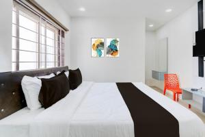 ein schwarzes und weißes Bett in einem weißen Schlafzimmer in der Unterkunft Hotel O Viraj Luxury Stay in Warangal + 26 Fotos