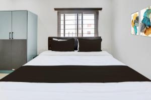 ein Schlafzimmer mit einem großen weißen Bett mit einem Fenster in der Unterkunft Hotel O Viraj Luxury Stay in Warangal