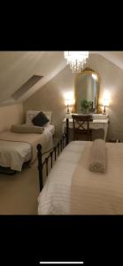 a bedroom with two beds and a mirror at Highcroft House in Corsham