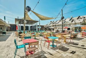 a group of tables and chairs with tables and chairs at Prominence Southside - Blue Skies in Watersound Beach