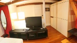 a living room with a television on a table at La casa degli Elfi a Monfalcone in Monfalcone