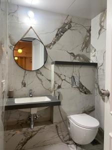 a bathroom with a sink and a toilet and a mirror at Flat in Viman Nagar in Pune