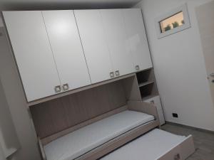 Una pequeña habitación con armarios blancos y un banco. en Appartamento a MXP Aeroporto-Via Mameli, en Somma Lombardo 6 fotos más