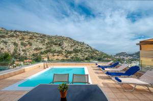 una piscina con sedie e una montagna di Villa Nikos a Palaiokastro