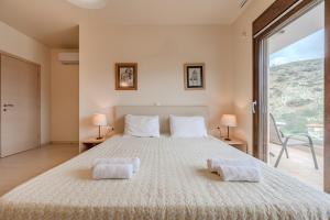 una camera da letto con un letto grande con due asciugamani sopra di Villa Paris a Palaiokastro