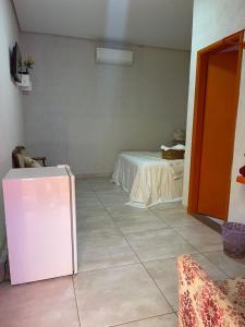 a room with a white refrigerator and a table at Villa da Serra Pousada in Piumhi