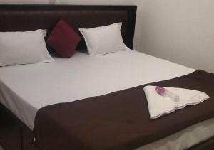 a bed with a bottle on top of it at All Seasons Guest House in Trivandrum