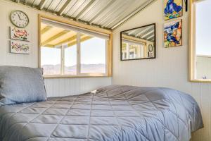 een slaapkamer met een bed en een klok aan de muur bij New Mexico Desert Hideaway! Pet-Friendly Tiny Home in Rodeo