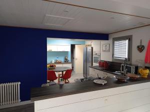 a kitchen with a counter and a blue wall at Les Bains in La Guérinière