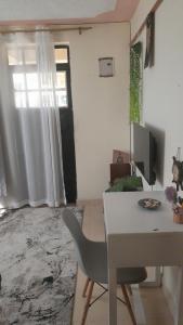 a room with a desk and a table with a chair at Swali residence in Nakuru