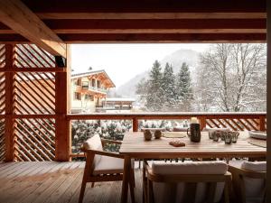 a wooden table and chairs on a deck with a view at Lodge Cresson - OVO Network in Châtel