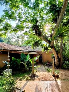 una casa con un árbol y una pasarela de ladrillos en Lotus and Moon, en Habaraduwa Central