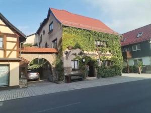 ein von Efeu bedecktes Gebäude an der Straßenseite in der Unterkunft Ferienwohnung Marie in Kurort Steinbach-Hallenberg