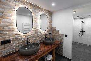 two sinks in a bathroom with two mirrors at Ferienhaus Köck in Kartitsch +91 photos