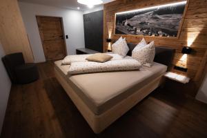 a bedroom with a large bed with white sheets and pillows at Ferienhaus Köck in Kartitsch