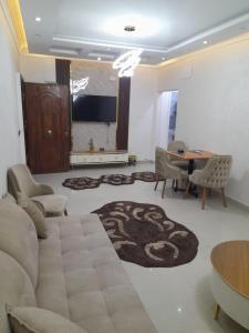 un soggiorno con un divano, un tavolo e delle sedie di عمارات ميلسا سيتى ستارز a Banī Ghālib 1 altra foto