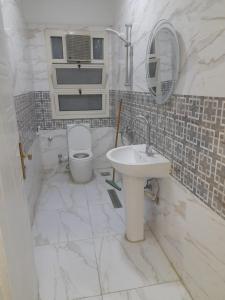 um banheiro branco com vaso sanitário e pia em عمارات ميلسا سيتى ستارز em Banī Ghālib