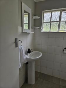 Un baño blanco con lavabo y espejo. en 48 Cintsa Bay, en Cintsa West 18 fotos más