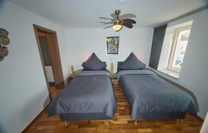 a bedroom with two beds and a ceiling fan at gemütliche 4 Zimmer Wohnung mit Einzelbetten, Küche und Badezimmer in Hohenmölsen +5 photos