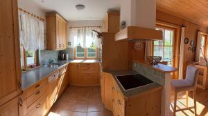 een grote keuken met houten kasten en een spoelbak bij Villa Verdi in Fischerndorf +4 foto's