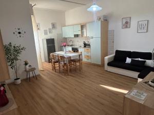 een keuken en een woonkamer met een tafel en een bank bij Casalileo in San Giovanni Suèrgiu