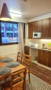 una cucina con tavolo e sedie e una cucina con bancone di Spacious 4 Bedroom rowhouse a Sodankylä