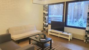 un soggiorno con divano e TV a schermo piatto di Spacious 4 Bedroom rowhouse a Sodankylä