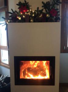 a fireplace with a christmas tree on top of it at Apartamentos Cangas Relax En Grupo in Cangas de Onís
