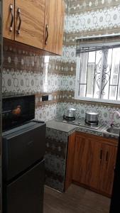 a kitchen with a black stove and a window at Daprem Self-Contain Service Apartments in Uyo