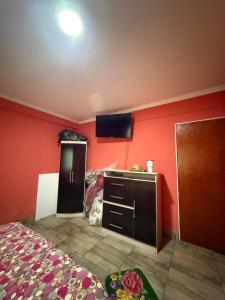 a bedroom with red walls and a bed and a sink at Quinta La Ramona in Candelaria