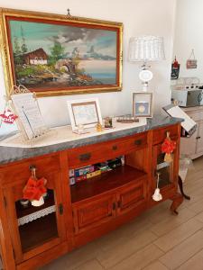 einen hölzernen Schreibtisch mit einem Gemälde an der Wand in der Unterkunft Amorevole villa con terrazza e parcheggio privato in Pozzuoli