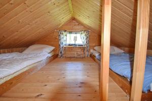 2 letti in una cabina di legno con finestra di Schwedentraum 