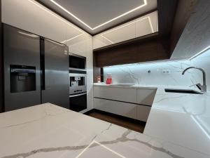 Una cocina con gabinetes blancos y encimera. en Riverside Residence, en Póvoa de Santa Iria