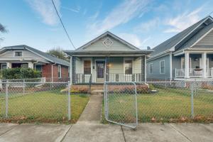 a fence in front of a house at Great for Long Stays! RVA Home with Yard Near Dtwn in Richmond