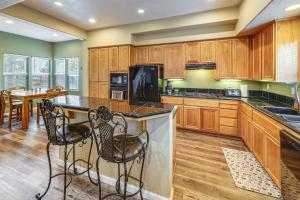 una cucina con armadi in legno e un'isola con sgabelli da bar di Napa Nearby! Large Home with Hot Tub and Dtwn Access a Suisun City