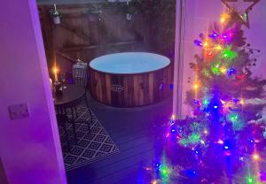 a christmas tree in a room with a tub at Elkstone Studio Private Hottub Pet Friendly in Malvern Link +32 photos
