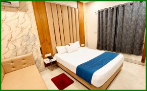Un dormitorio con una cama blanca grande y una ventana en Mahakaleshwar Jyotirlinga Temple Hotel A- Palace Near Railway Station - Parking with Room Service, fully air Conditioning Rooms - Best Hotel in Ujjain, en Ujjain