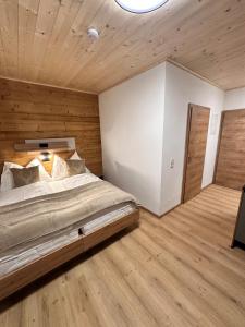 een slaapkamer met een groot bed en houten wanden bij Alpin Studio Schladming 101 in Schladming