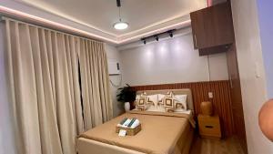 1 dormitorio pequeño con cama y cortinas en Dagaya Suites, en Bacolod 14 fotos más