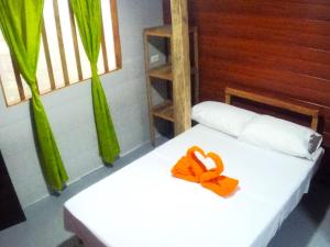 a room with two beds with orange bows on them at Hostal Oasis Day in Buenaventura