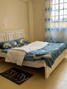 twee eenpersoonsbedden in een kamer met een raam bij chomama homes in Ngong