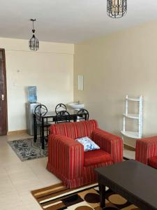 een woonkamer met twee rode banken en een tafel bij chomama homes in Ngong