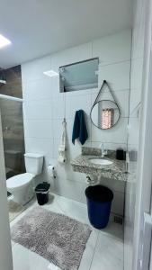 a bathroom with a toilet and a sink and a mirror at Kitnet do Recanto em Guriri in São Mateus +12 photos