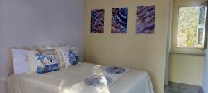 a bedroom with a white bed with two pictures on the wall at Vila Pescador Fortim in Fortim