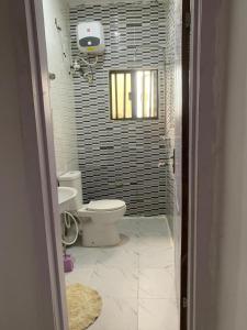 ein Badezimmer mit Toilette und Fenster in der Unterkunft Vivi apartment hotel and suite in Sapele