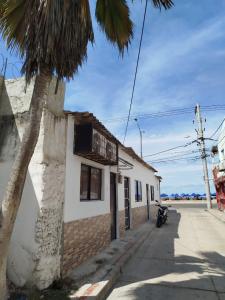 a building with a palm tree next to a street at Apartaestudio Marbella #2-10 in Cartagena de Indias