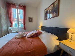 Le Cerf - Rambouillet city center في رامبوييه: غرفة نوم بها سرير كبير وبطانية حمراء